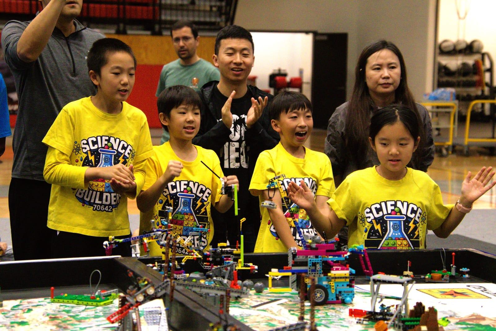 A FIRST LEGO League team in yellow shirts cheering their robot at the competition table, Texas State Championship 2026