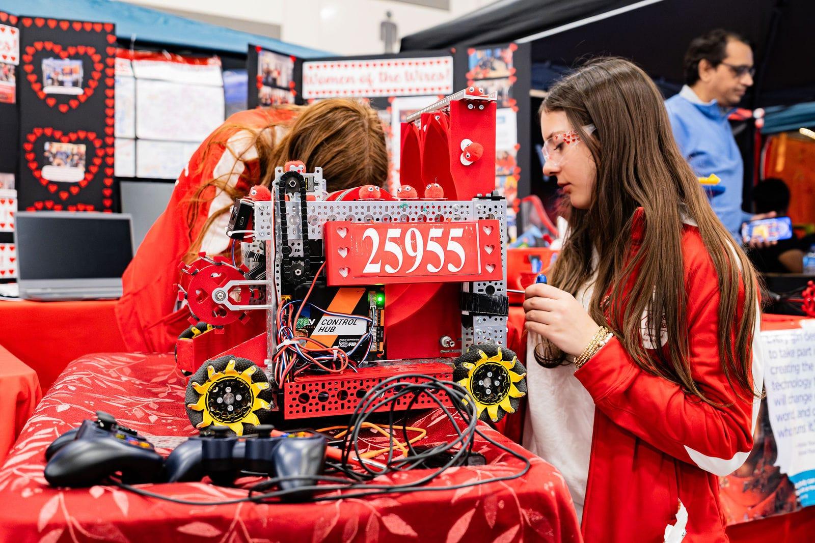 Two FIRST Tech Challenge team members working on their robot in the pit at the Texas Cup